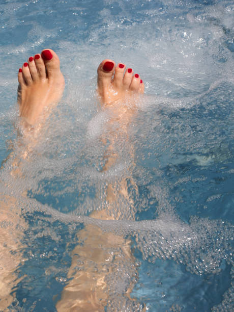 istock feet with red nail polish in spa water during hydrotherapy and massage session 2185778626