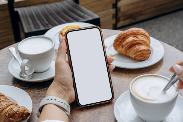 istock Mockup woman's hand holding using smart phone with white blank screen POV at coffee shop, mobile app design and advertising, online marketing 2185780701