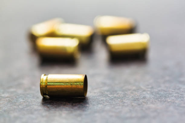 Empty 9mm cases on a background of textured tile.