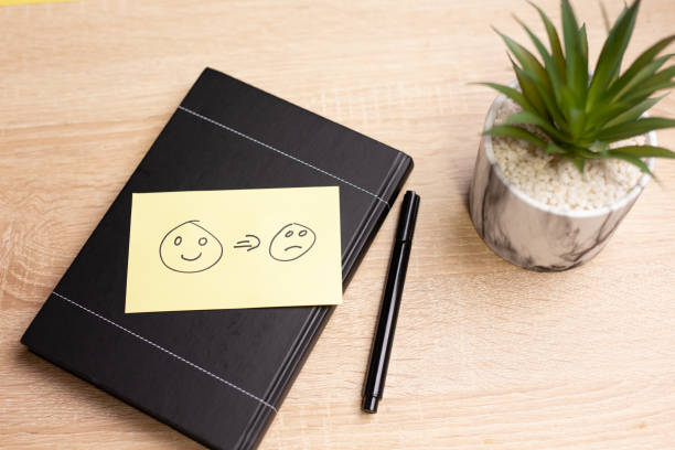 istock Sticky note showing mood change from happy to sad on a notebook 2185785413