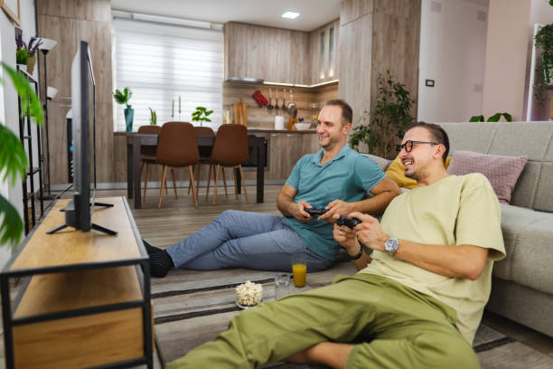 istock Two smiling men playing video games at home 2185785873