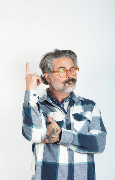 istock Handsome middle-aged man pointing finger up at advertisement in promotional text copyspace. 2185786321