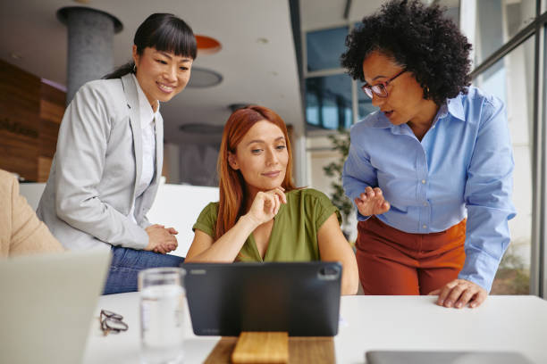 istock Diverse Businesswomen Collaborating on a Tablet in Modern Office 2185790850