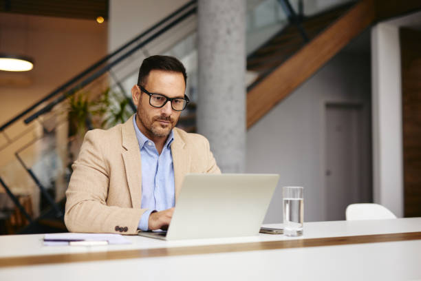 istock Focused Businessman Working on Laptop in Modern Office Setting 2185790915