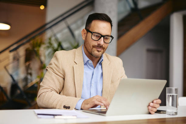 istock Focused Businessman Working on Laptop in Modern Office Setting 2185790916