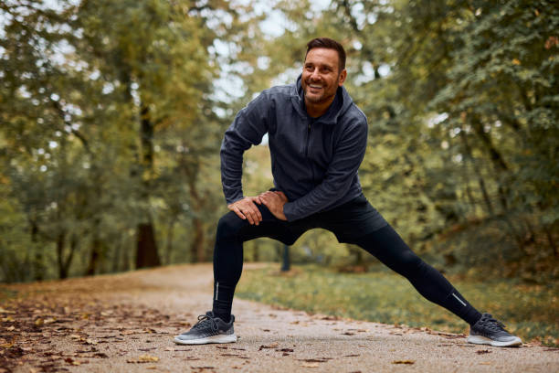istock Active Man Stretching in Forest Park for Fitness Routine 2185791056