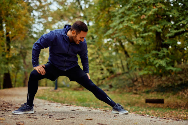 istock Active Man Stretching in Forest Park for Fitness Routine 2185791062