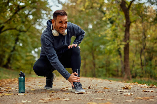Injured Jogger On Park Pathway During Autumn