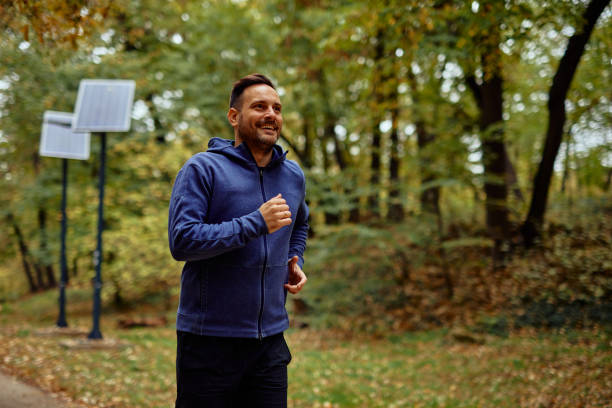 istock Man Jogging Through a Scenic Forest Trail in Autumn 2185791410