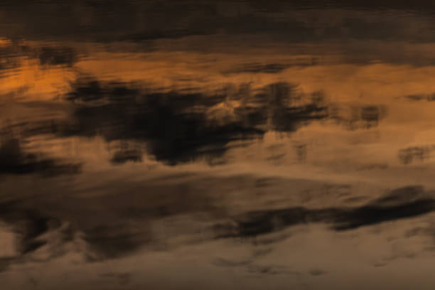 This mesmerizing and captivating abstract reflection of a stunning sunset in tranquil waters evokes a serene atmosphere