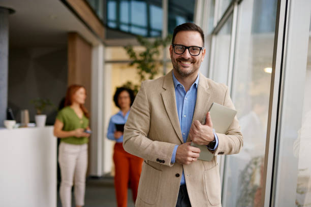 istock Confident Businessman Holding Laptop In Modern Office Corridor 2185793075