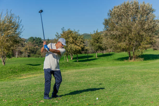 istock copyspace elderly golfer with cap and sunglasses hitting ball with driver during golf tournament 2185794875