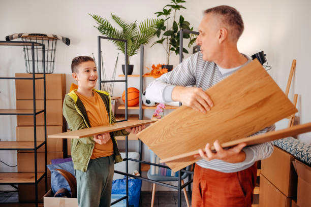 istock Father and son moving in new home and assembling shelf together 2185796450
