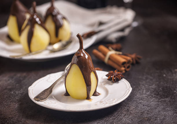 Preparing poached pears glazed with dark chocolate for the Christmas holidays