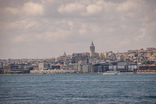 The majestic Galata Tower stands out among modern buildings in Istanbul, capturing the blend of old and new architectural styles in this vibrant cityscape shot.