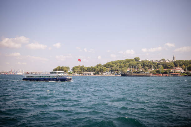 A scenic view capturing a ferry gracefully gliding across the vivid blue waters on a clear day, exhibiting the beauty and serenity of water transport and travel.