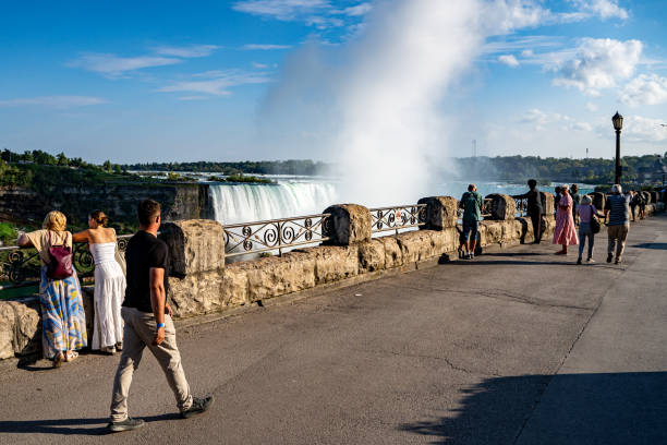 Horseshoe Falls at Niagara viewed from the Canadian side of the River Niagara.  There are tourists at a look out point looking at the American Falls. Niagara falls, Ontario, Canada.