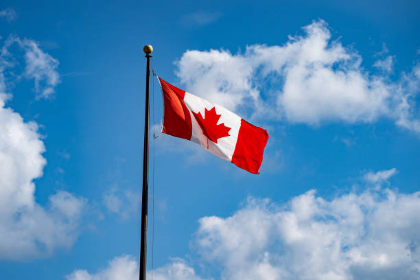istock Waving Canadian flag and cloudy blue sky. 2185804480