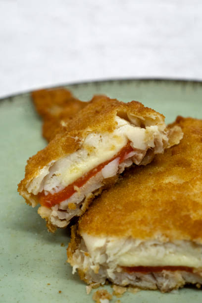 istock Closeup view of battered hake filets stuffed with red bell pepper and cheese 2185808003