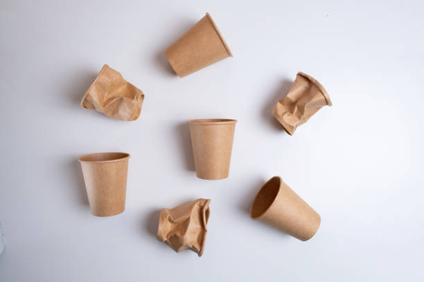 istock Eco-friendly paper coffee cups on light background. Zero waste, plastic-free products. Whole and dented glass. Stop plastic pollution. Mockup 2185808303