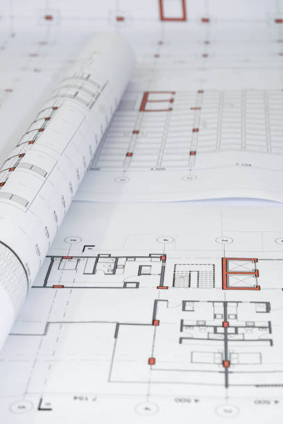 istock vertical view of rolled architectural and construction plans. Residential building design. Technical blueprints for projects 2185822130