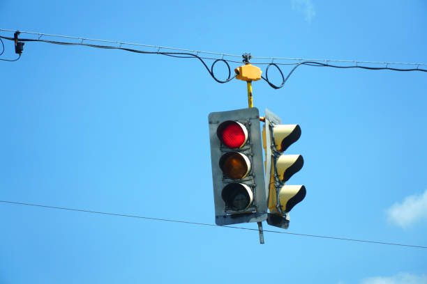 istock red traffic light hanging against sky 2185823557