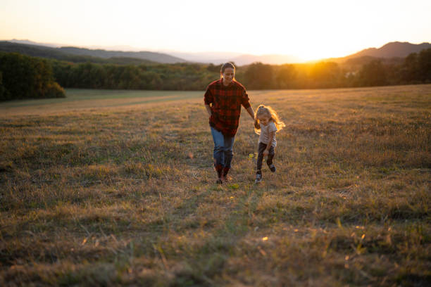 istock Family Day Outdoors. Holding Hands While Hiking at Sunset 2185825090