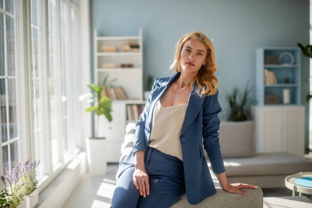 istock Chic woman in blue suit reflects by sunlit windows 2185826516