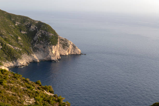 Scenic view of rugged cliffs and the tranquil Ionian Sea at Zakynthos Island, Greece, a popular tourist destination known for its natural beauty and serene landscapes.