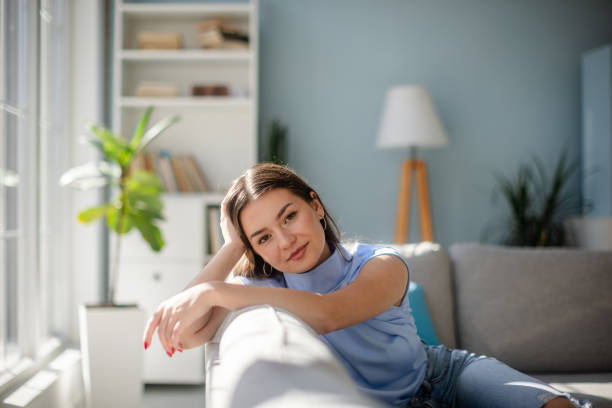 istock Pensive young woman resting on sofa in thoughtful mood. 2185828905