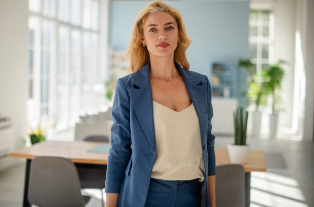 istock Poised businesswoman standing in bright open office 2185829018