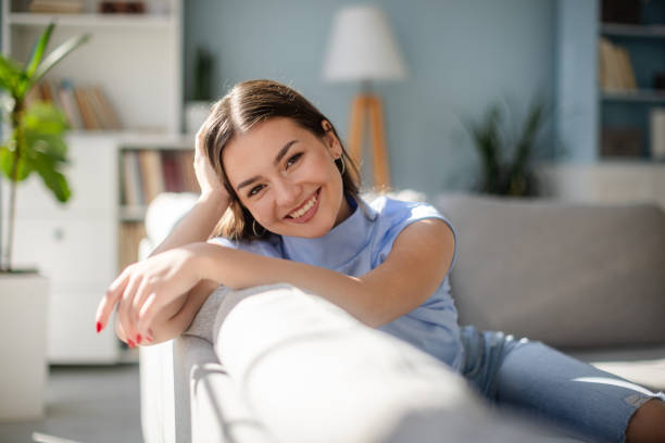 Smiling woman on sofa in contemporary home interior