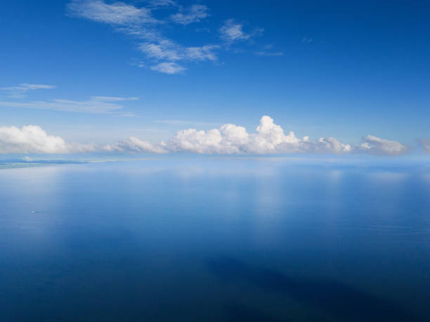 istock Serenity of open sea under clear blue sky with fluffy clouds 2185837177