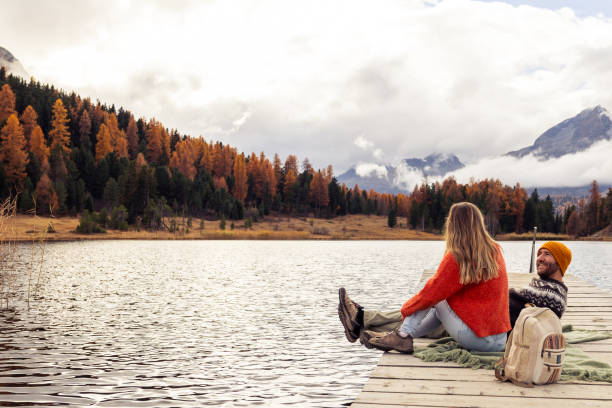 istock Couple Relaxing by a Serene Mountain Lake 2185844734
