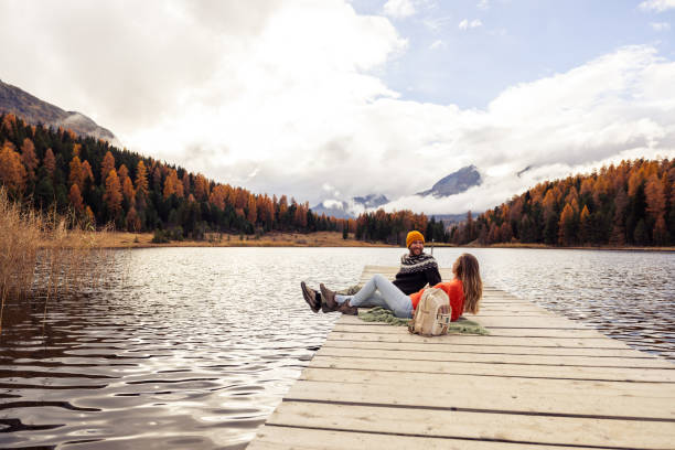 istock Couple Relaxing by a Serene Mountain Lake 2185844735