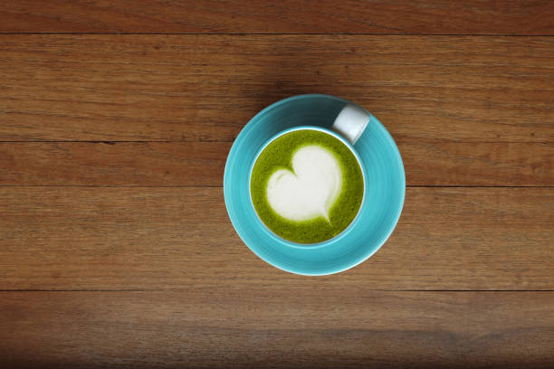 A cup of green tea matcha latte on wooden background