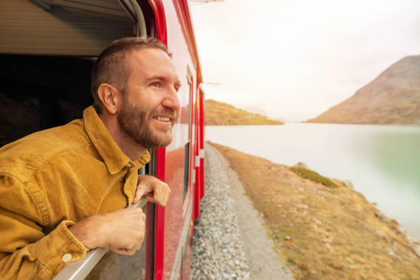 istock Male passenger train enjoys the panorama from an opened window 2185848976