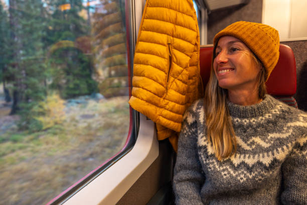 istock Woman Smiling by Train Window with Autumn Views 2185849021