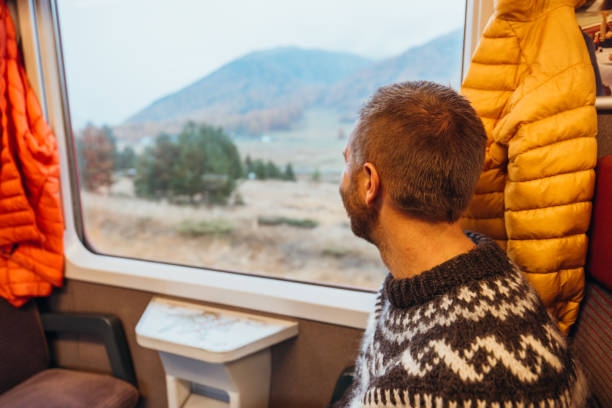istock Man Gazing Out Train Window on Scenic Journey 2185849029