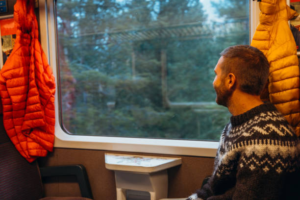 istock Man Gazing Out Train Window on Scenic Journey 2185849040