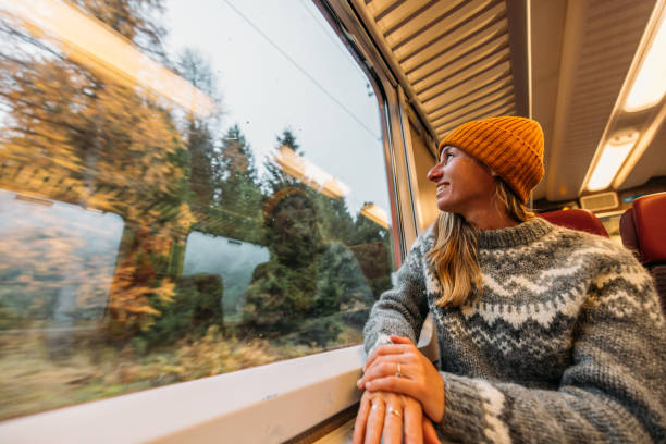 istock Woman Smiling by Train Window with Autumn Views 2185849049