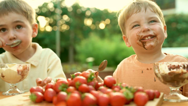 istock Cute Brothers Smiling and Enjoying Ice Cream in Yard 2185850014