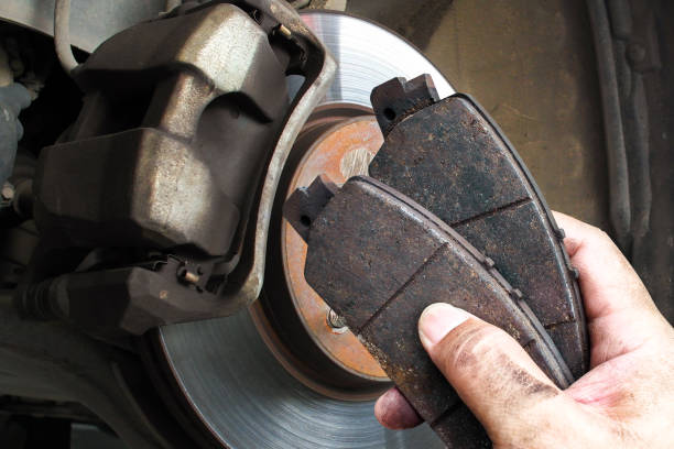 istock Auto mechanics replace worn brake pads to maintain a car braking system 2185858168