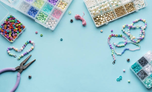 istock Colorful assortment of beads and jewelry-making tools on a blue surface with completed bracelets 2185860021