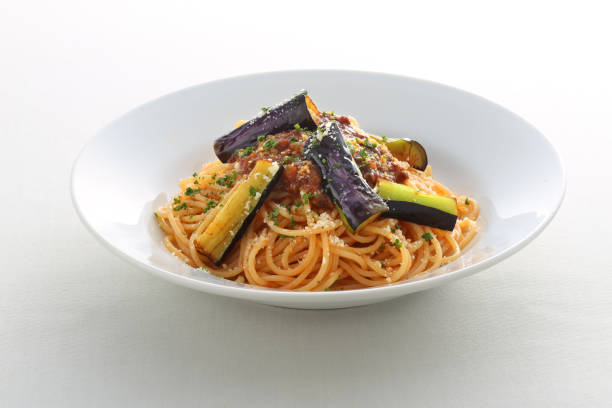 A plate of pasta with root vegetables, leafy vegetables, and beans