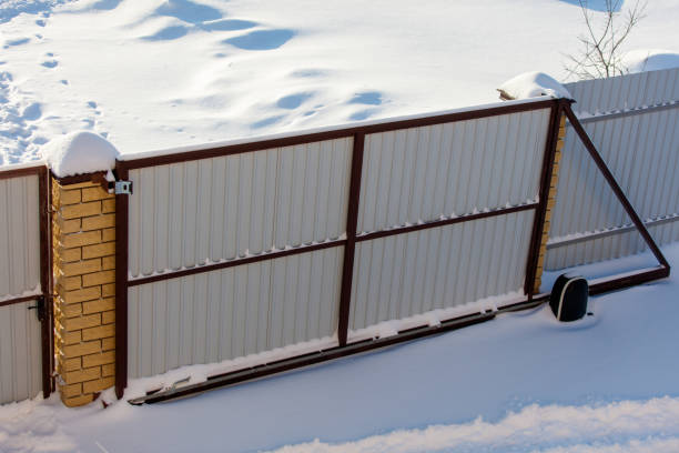 istock A gate is covered in snow and has a black box on it 2185863339