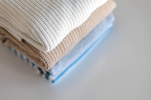 istock Neatly folded warm knitted sweater stack clothes storage top view isolated on white 2185866416