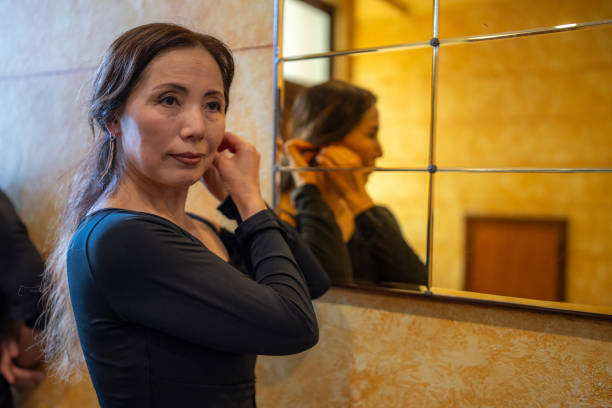 istock Woman Adjusting Earring in Front of Mirror 2185866598