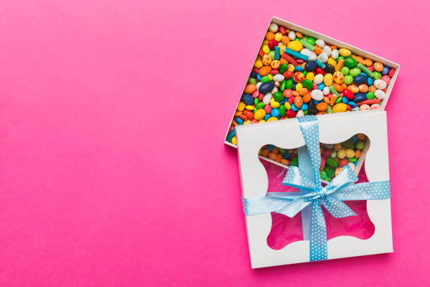 istock Box with sweet chocolate candies on color background, Various candy sweets. Valentines day gift box. Top view flat lay with copy space 2185868990