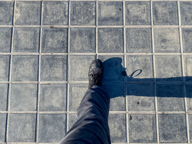 Directly above view of a male foot on a tiled floor sidewalk in the city of Valencia, Spain